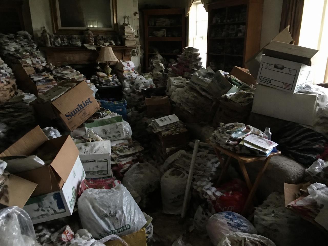 Hoarded living room packed with clutter, boxes and bags before CP Cleaning